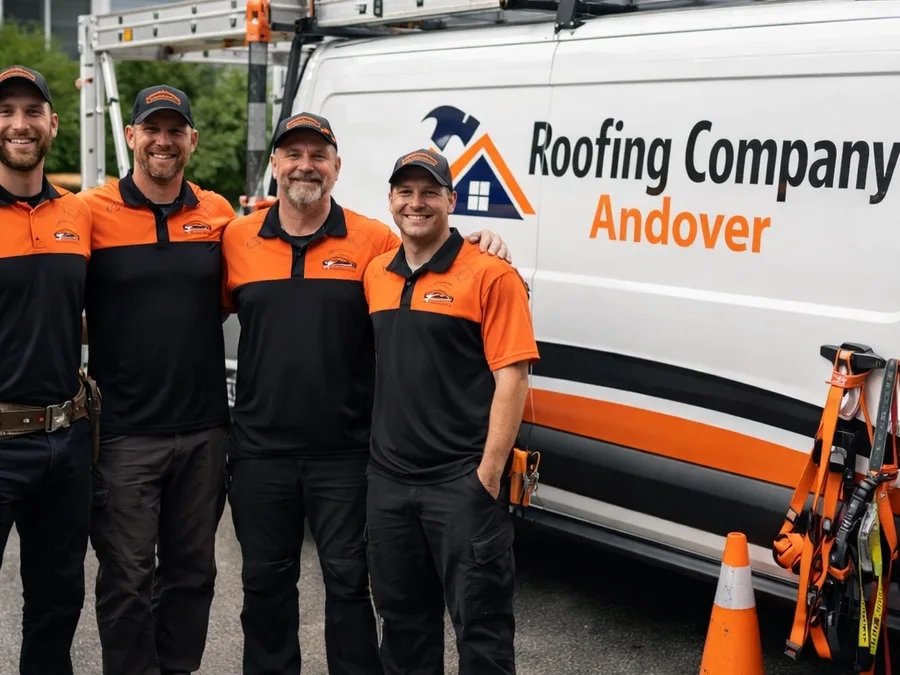 Small roofing crew in branded workwear beside a work truck in a residential driveway with visible safety equipment